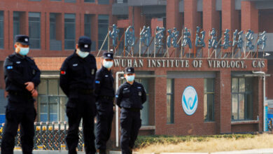 FILE PHOTO: Security personnel keep watch outside Wuhan Institute of Virology during the visit by the World Health Organization (WHO) team tasked with investigating the origins of the coronavirus disease (COVID-19), in Wuhan, Hubei province, China February 3, 2021. To match Special Report GLOBAL-PANDEMICS/BATS-ORIGINS REUTERS/Thomas Peter/File Photo