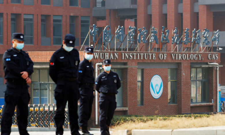 FILE PHOTO: Security personnel keep watch outside Wuhan Institute of Virology during the visit by the World Health Organization (WHO) team tasked with investigating the origins of the coronavirus disease (COVID-19), in Wuhan, Hubei province, China February 3, 2021. To match Special Report GLOBAL-PANDEMICS/BATS-ORIGINS REUTERS/Thomas Peter/File Photo